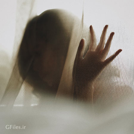 عکس سایه زن در پشت شیشه مات با ژست هنری
