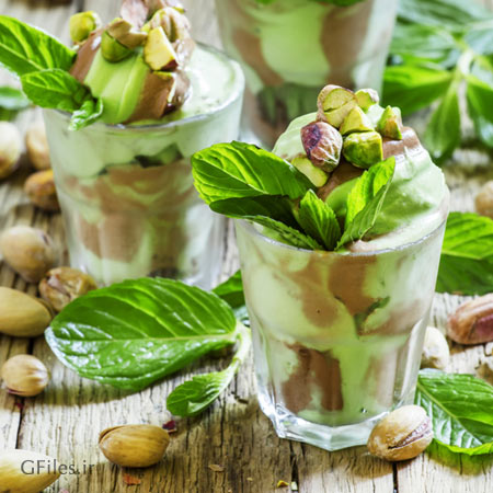 دانلود عکس بستنی در لیوان شیشه ای با تزیین پسته تازه به همراه برگ آن